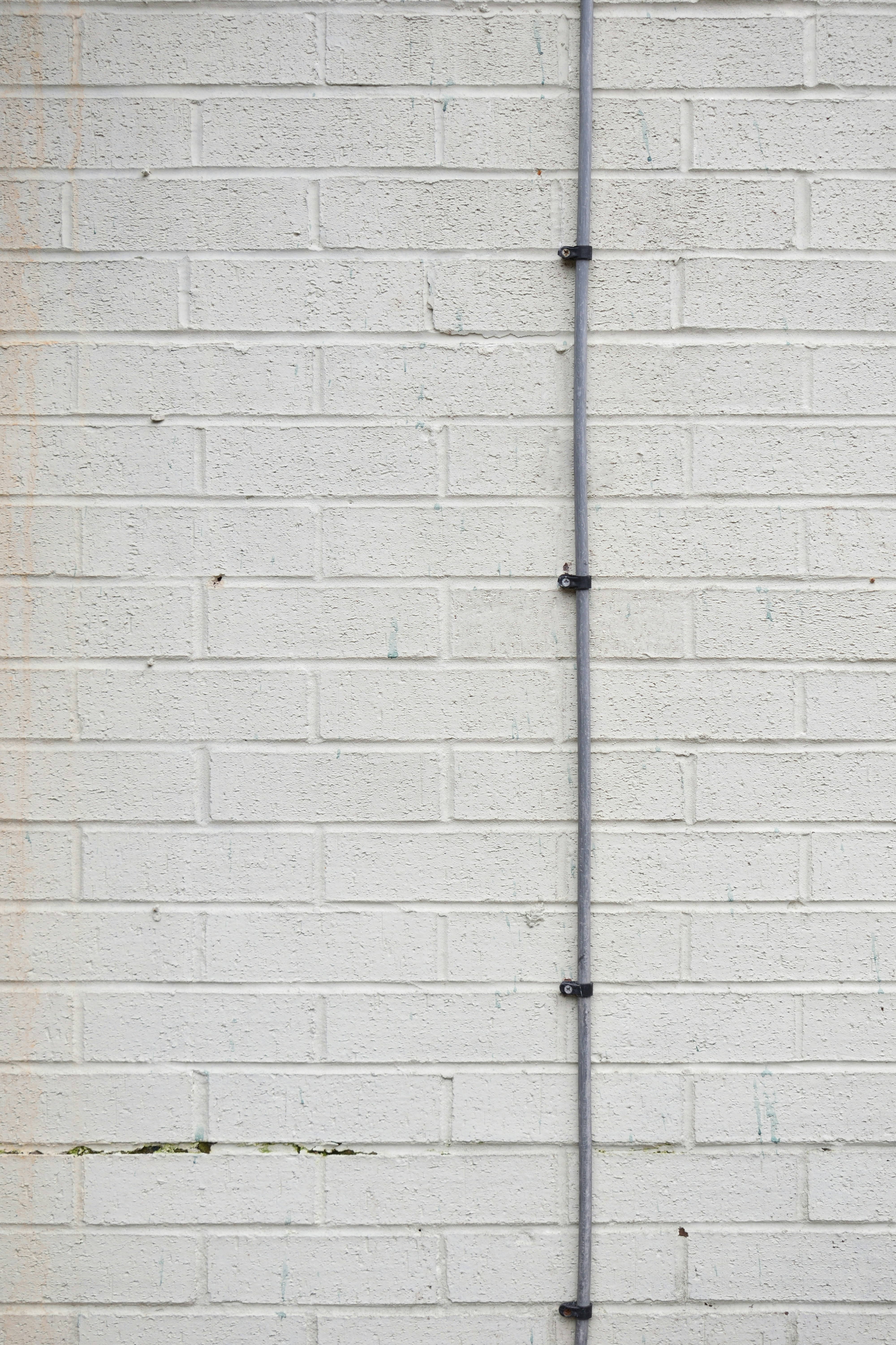 a red fire hydrant in front of a white brick wall