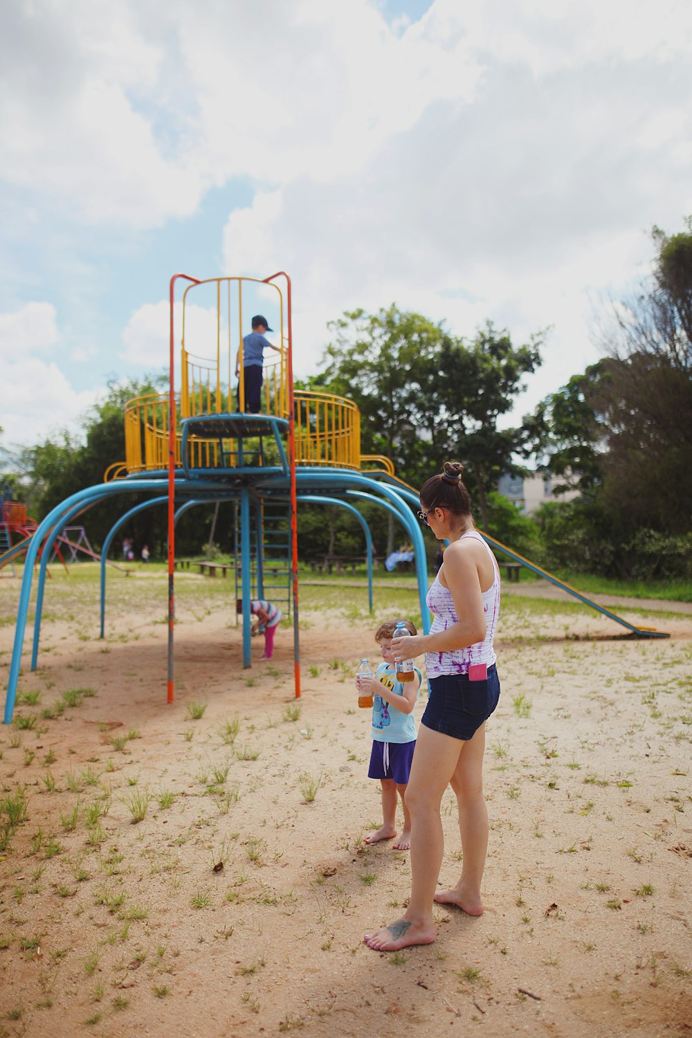 a man and a little girl standing in front of a playground