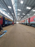 Technicians inspecting a rail car’s undercarriage in a spacious workshop.