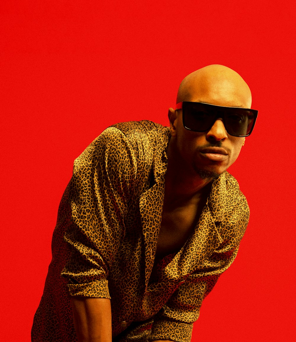 a bald man wearing sunglasses and a leopard print shirt
