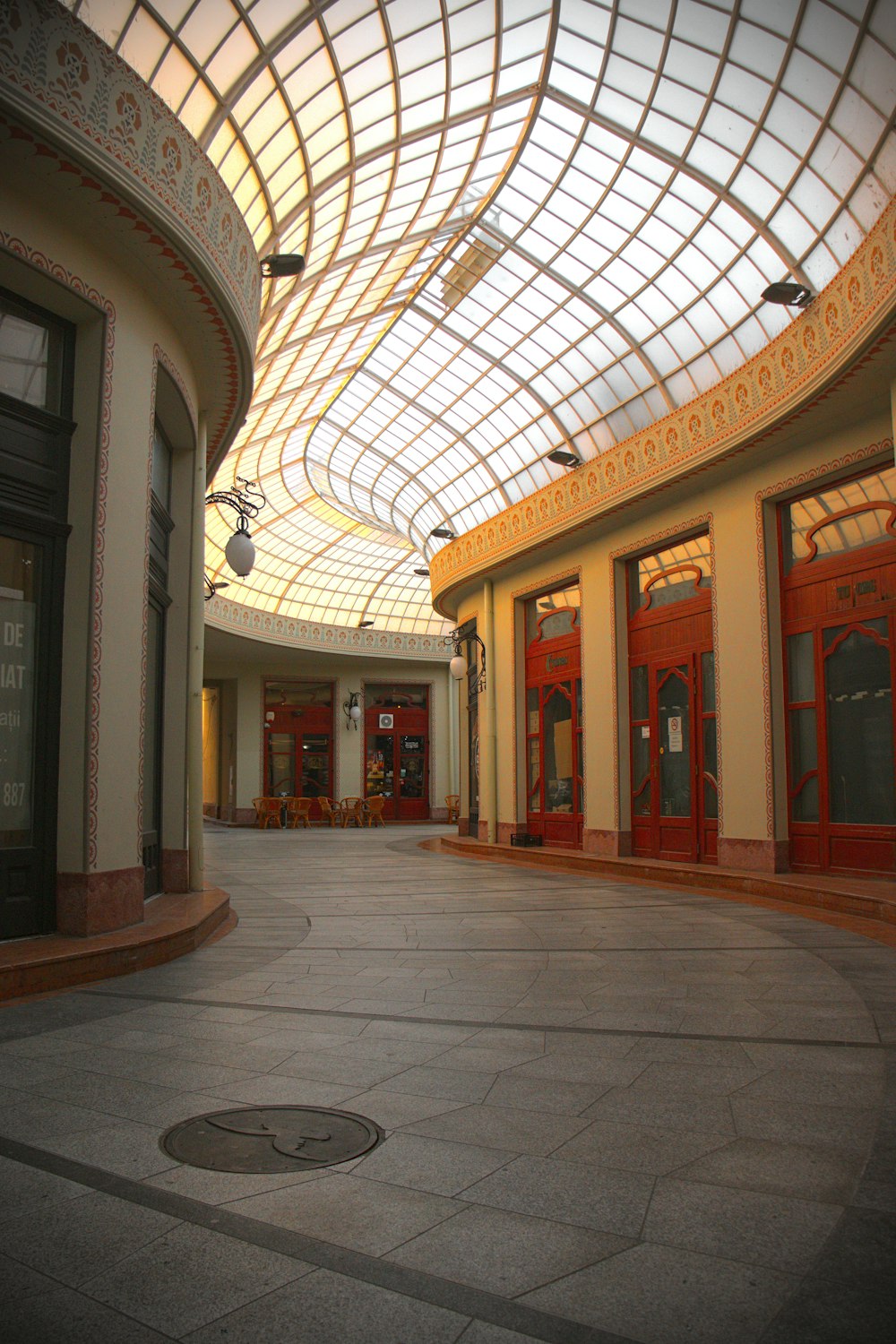 Un centro comercial vacío con techo de cristal