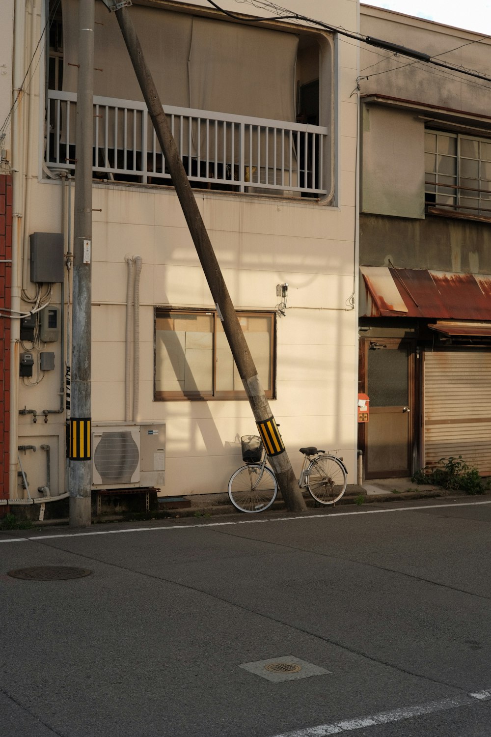 a bicycle leaning against a pole on a city street