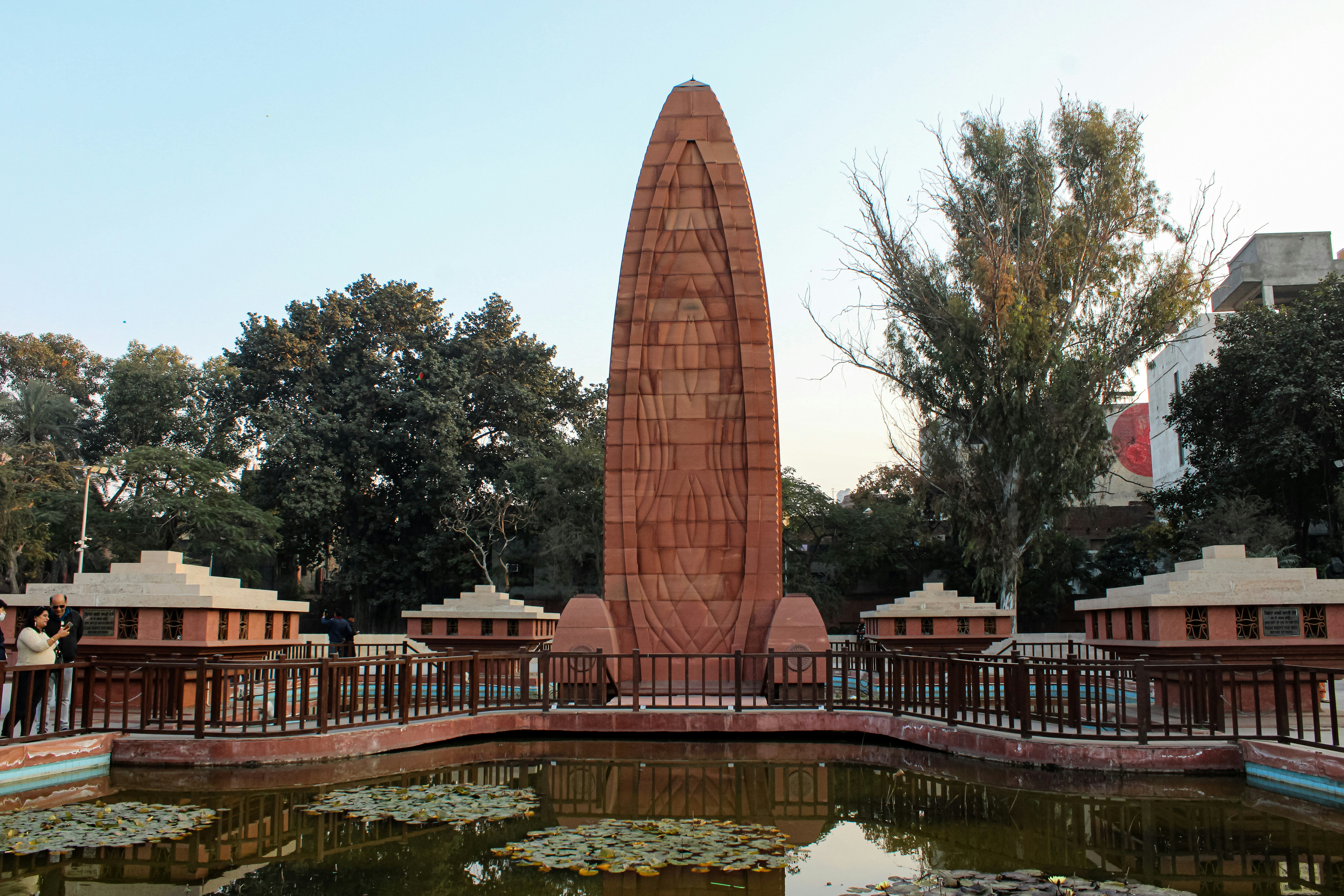 a large monument in a park next to a pond