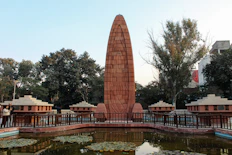 a large monument in a park next to a pond