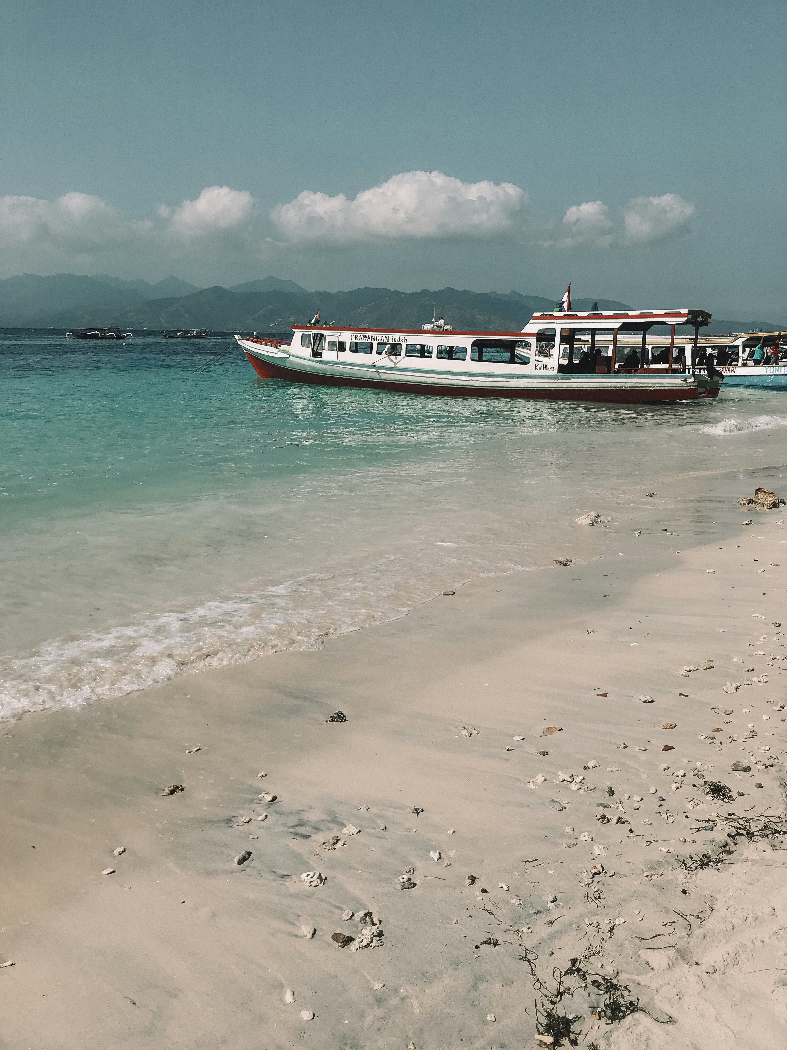 a boat is sitting on the shore of a beach