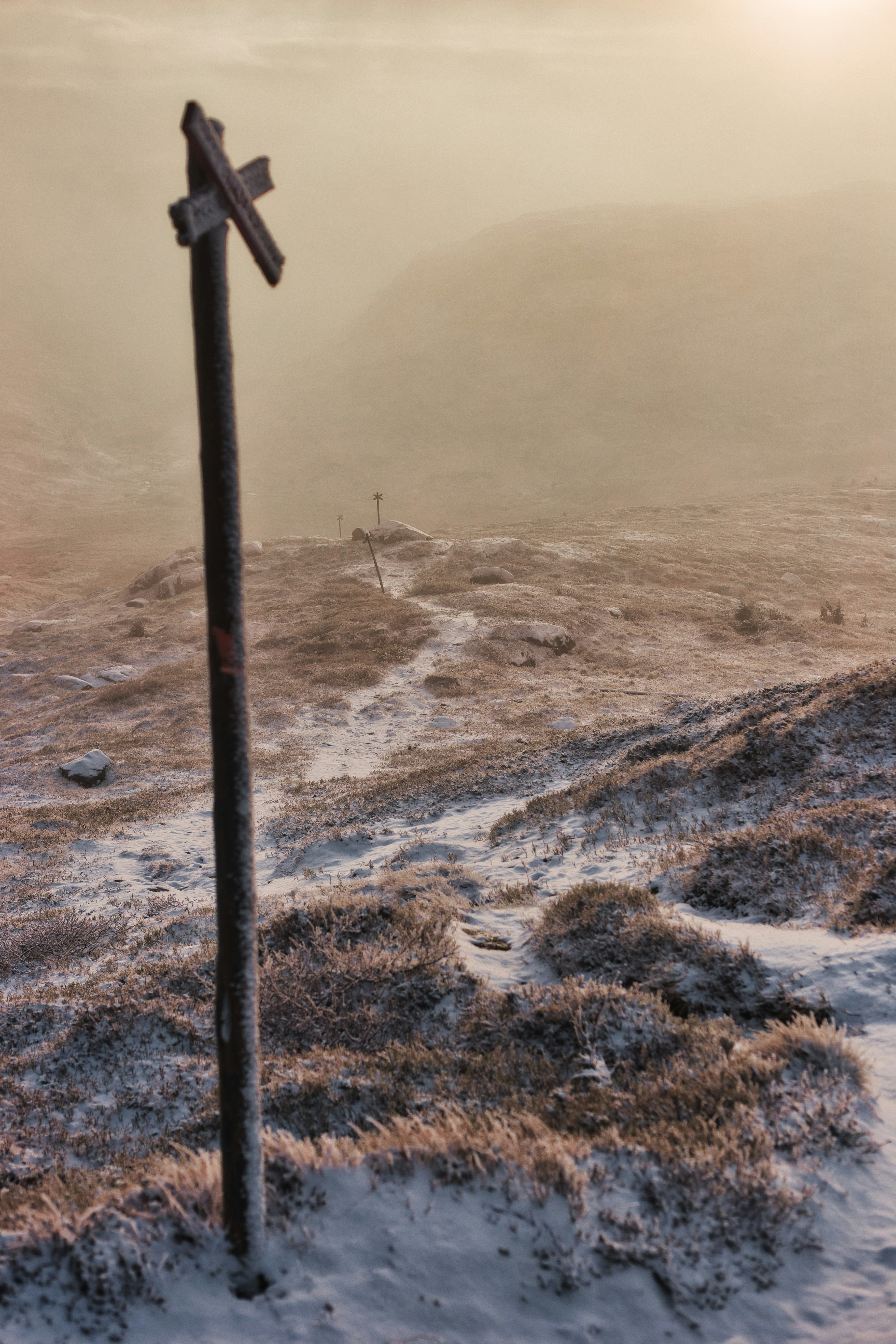 a pole that has a sign on a dirt field