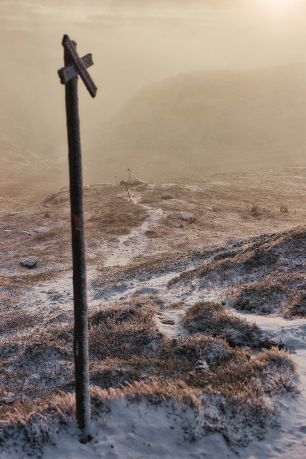 a pole that has a sign on a dirt field