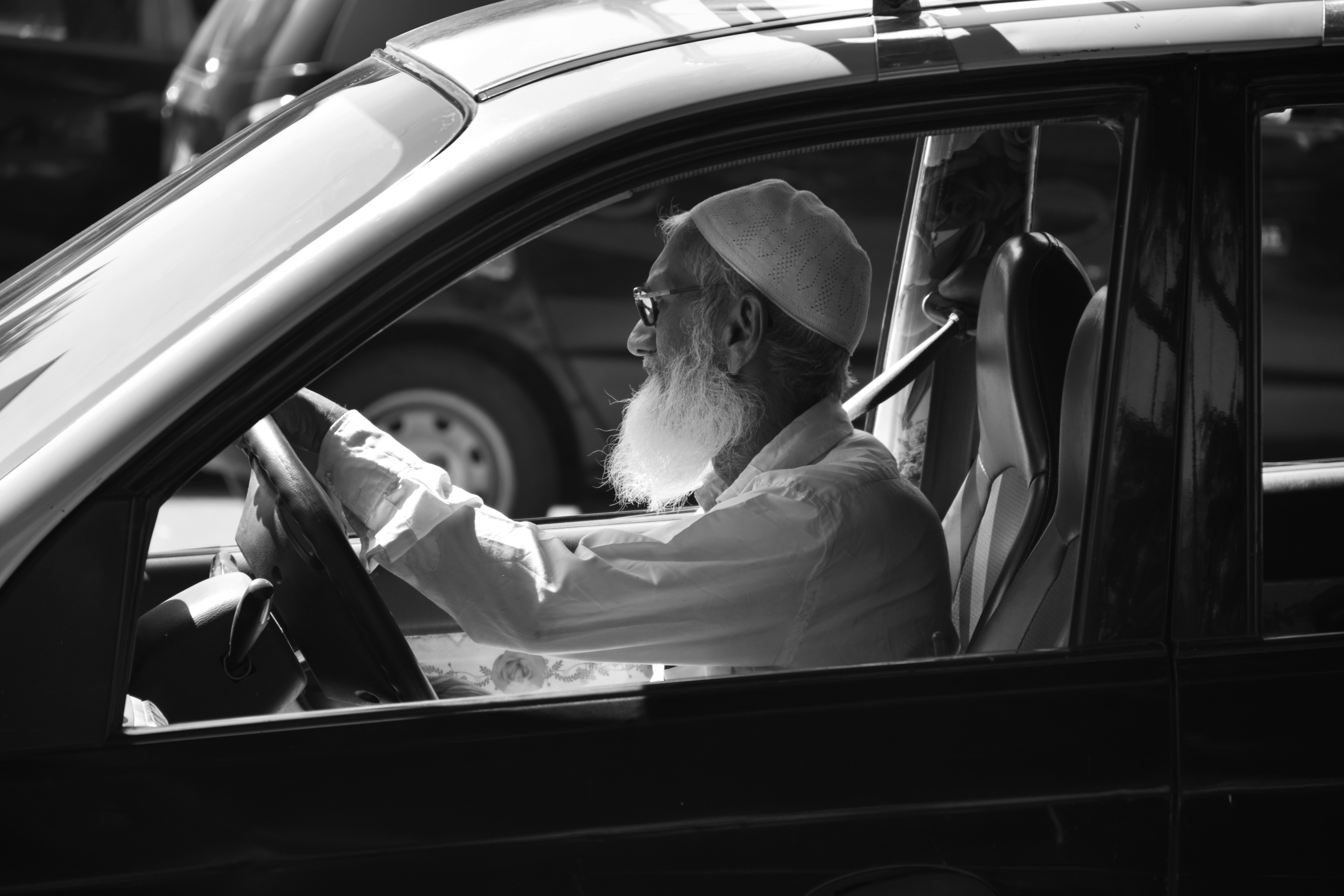 a man with a long white beard driving a car
