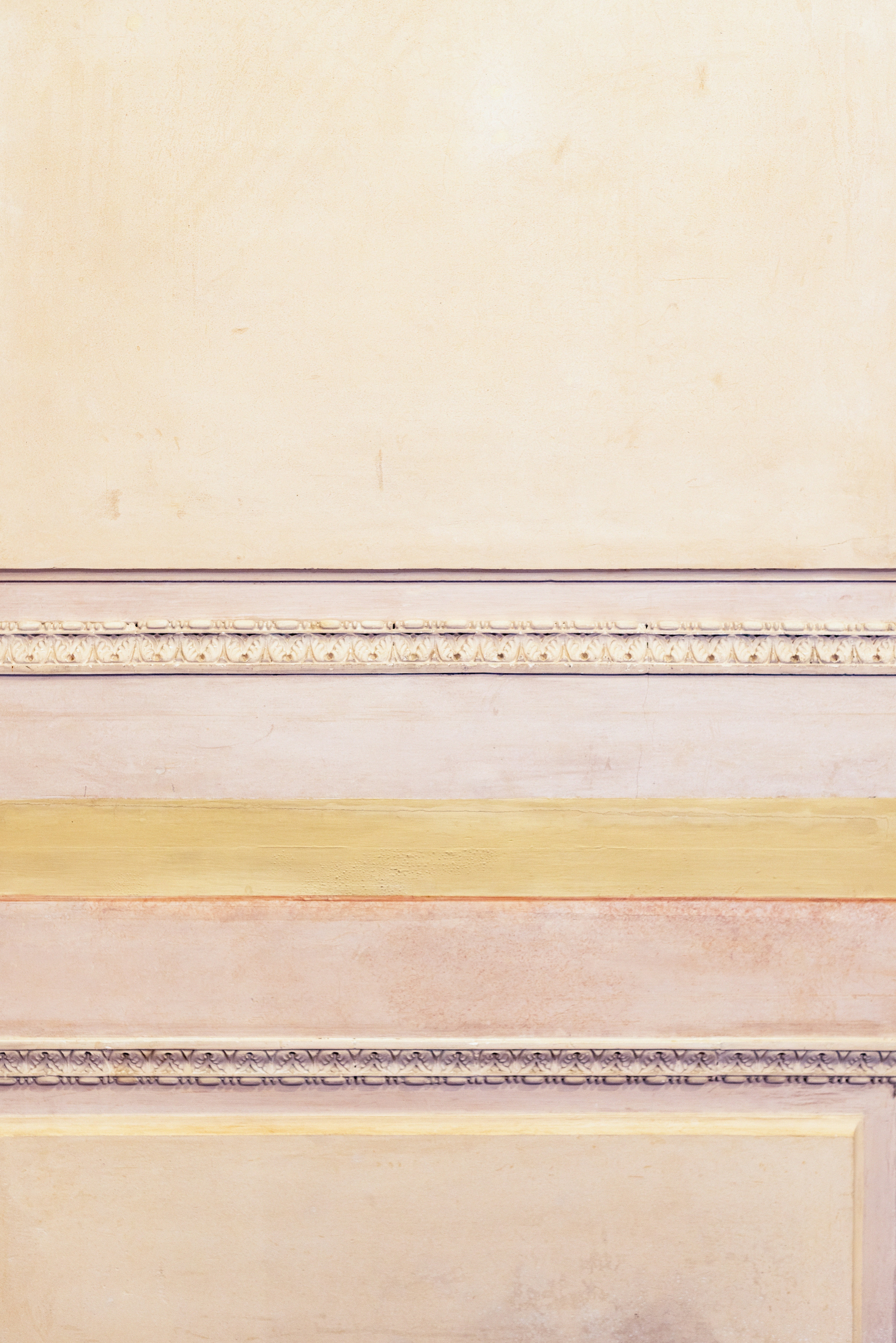 壁の前のベンチに座っている男