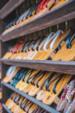 A row of finished sandals made from recycled tires displayed on a wooden shelf.