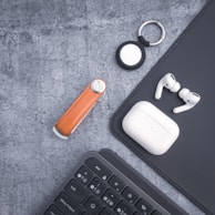 A flat lay of several keychains arranged neatly on a soft pastel fabric background.