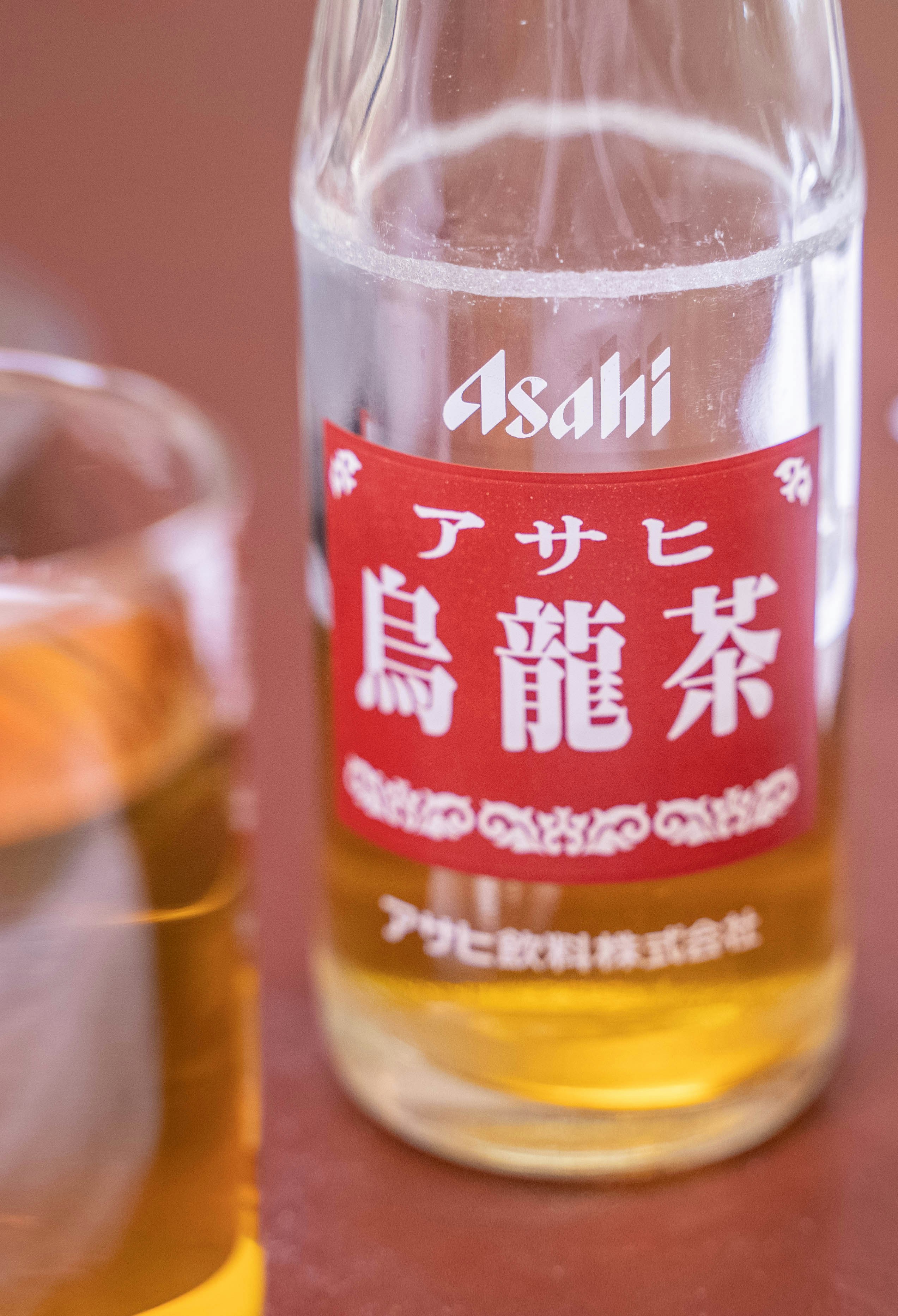 グラスの隣のテーブルに座っているアルコールのボトル