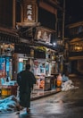 a man walking down a street at night