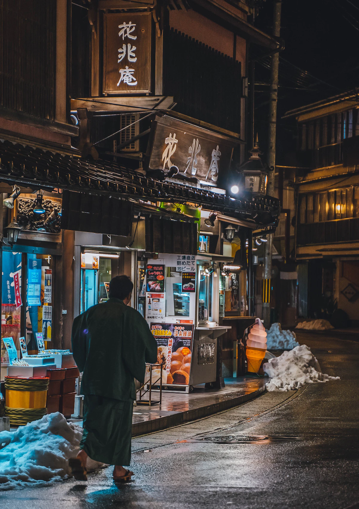 A Japanese man walking through the lantern-lit streets of Kinosaki Onsen at night, wearing a yukata