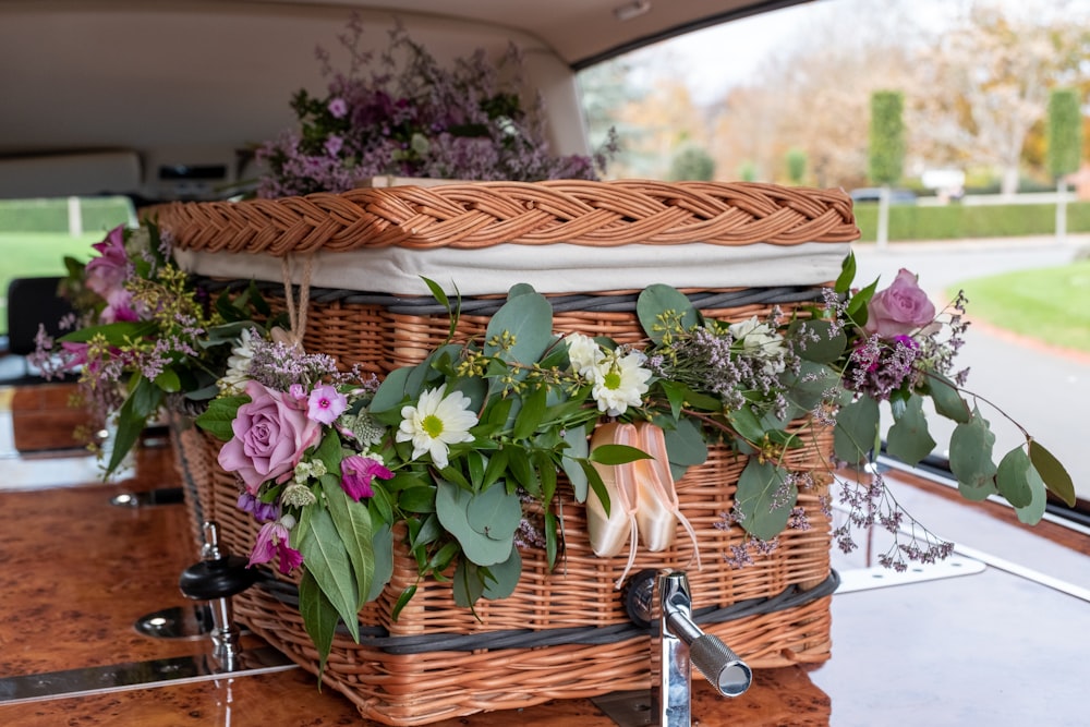 a basket filled with flowers sitting on top of a wooden table