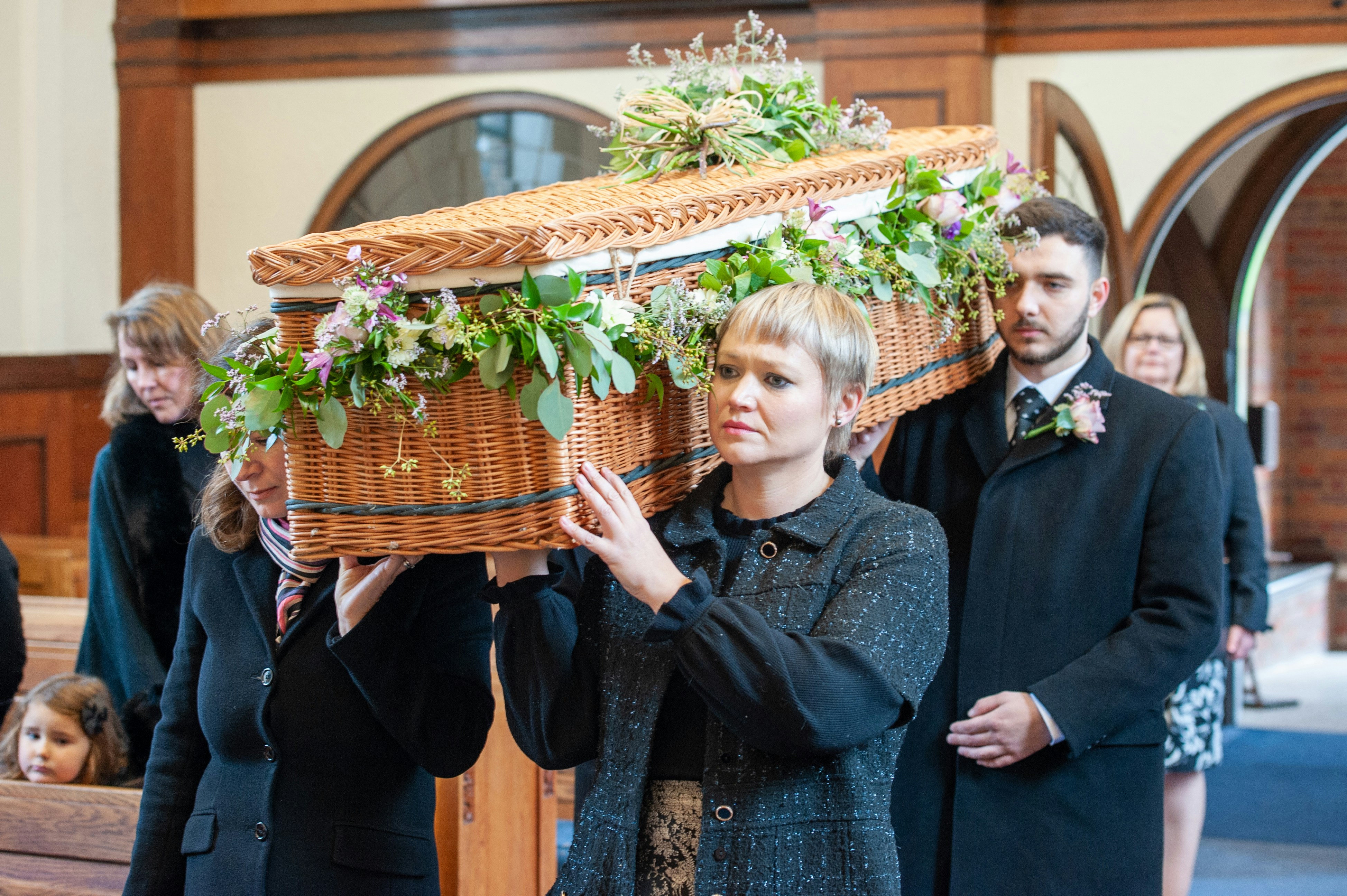 Pallbearers carrying a coffin at a funeral.