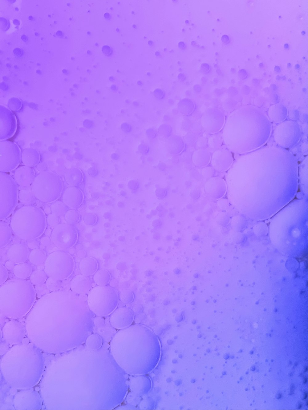Un primer plano de burbujas en un líquido azul y rosa