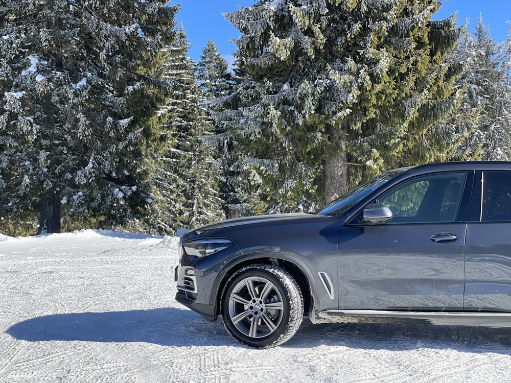 a grey bmw suv parked in the snow