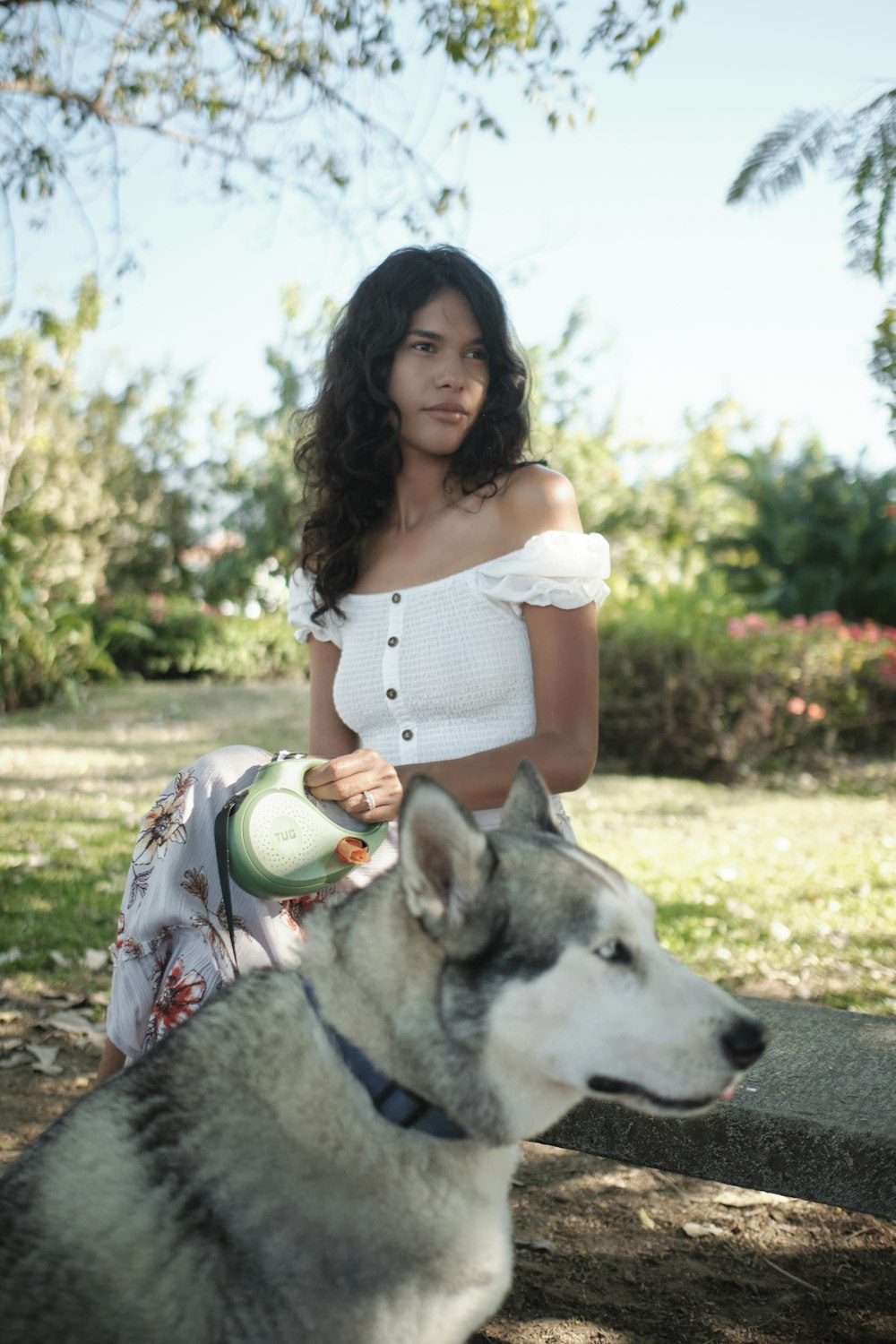 a woman sitting on a bench next to a dog