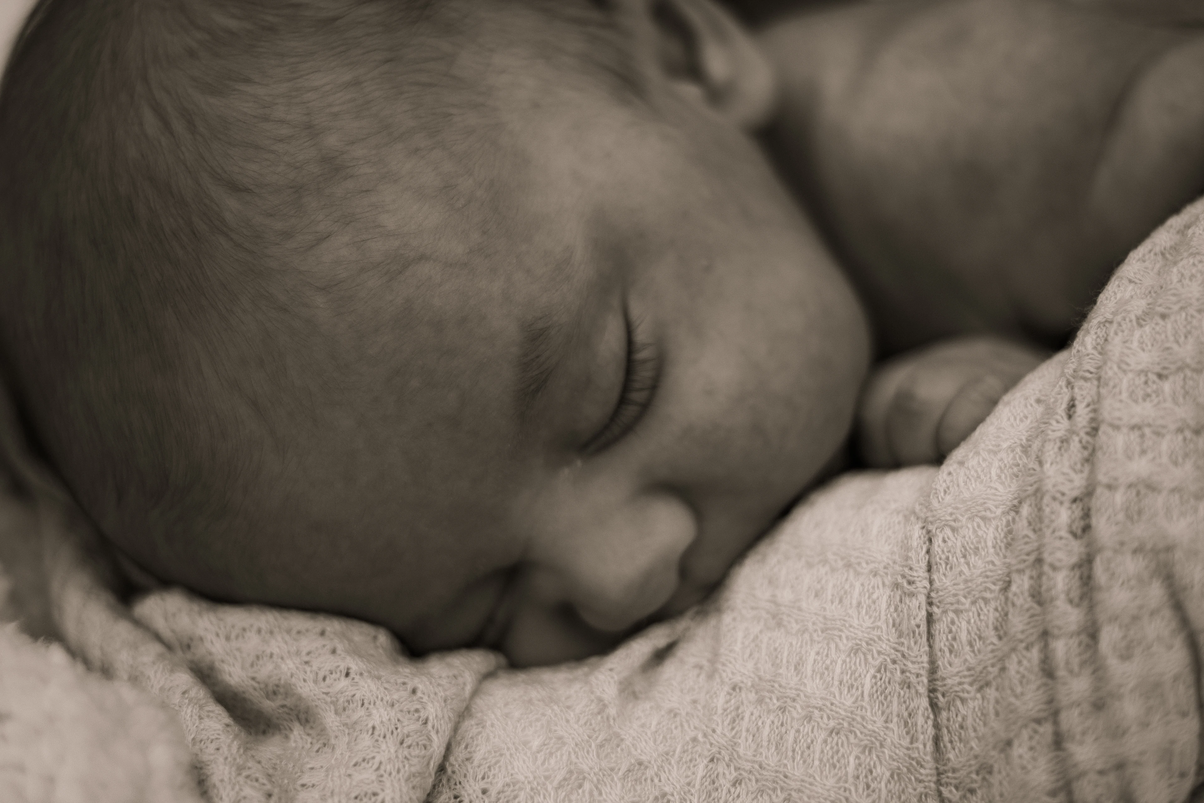 A newborn baby asleep on a blanket