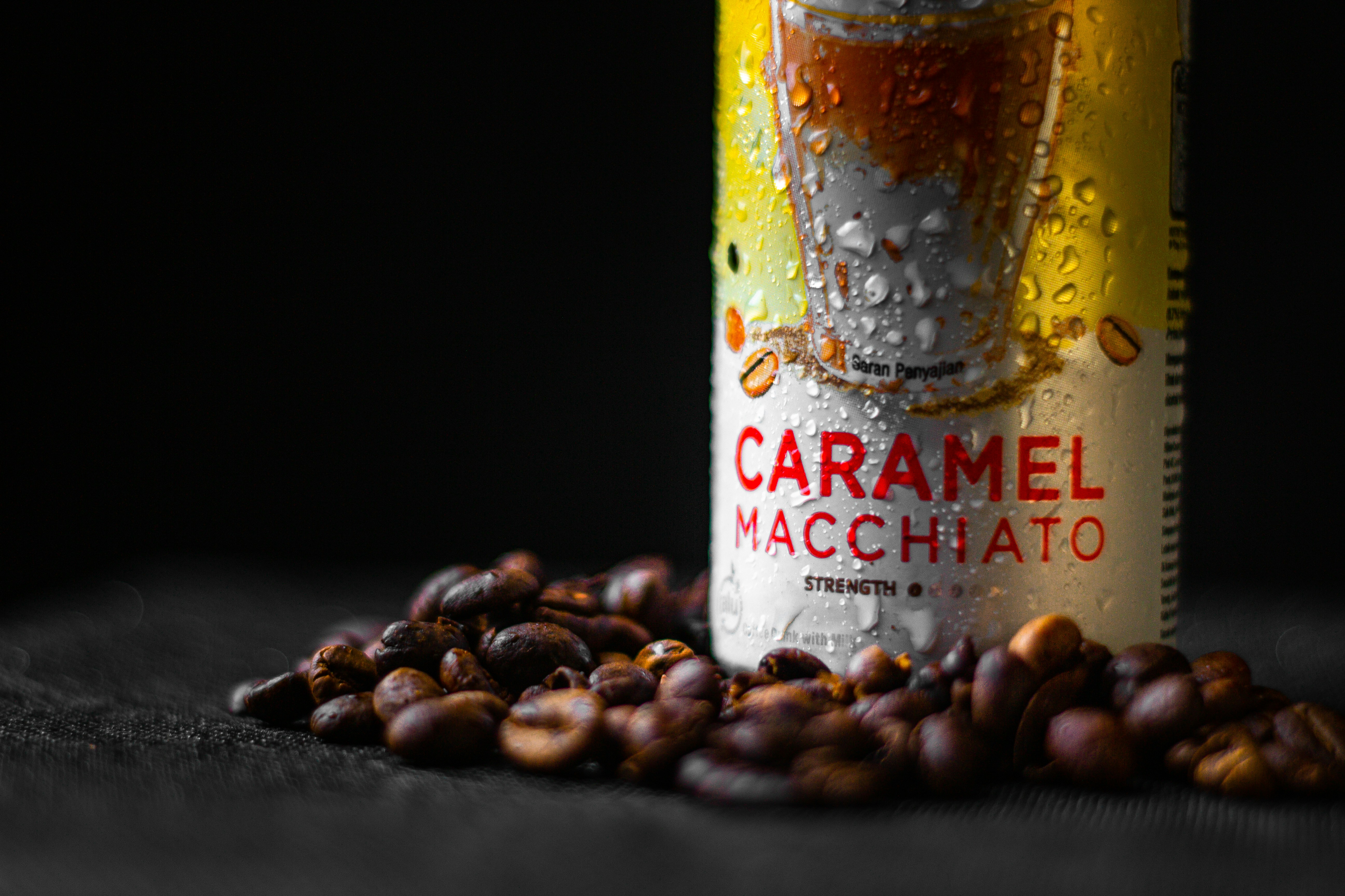 a can of caramel macchato next to a pile of nuts