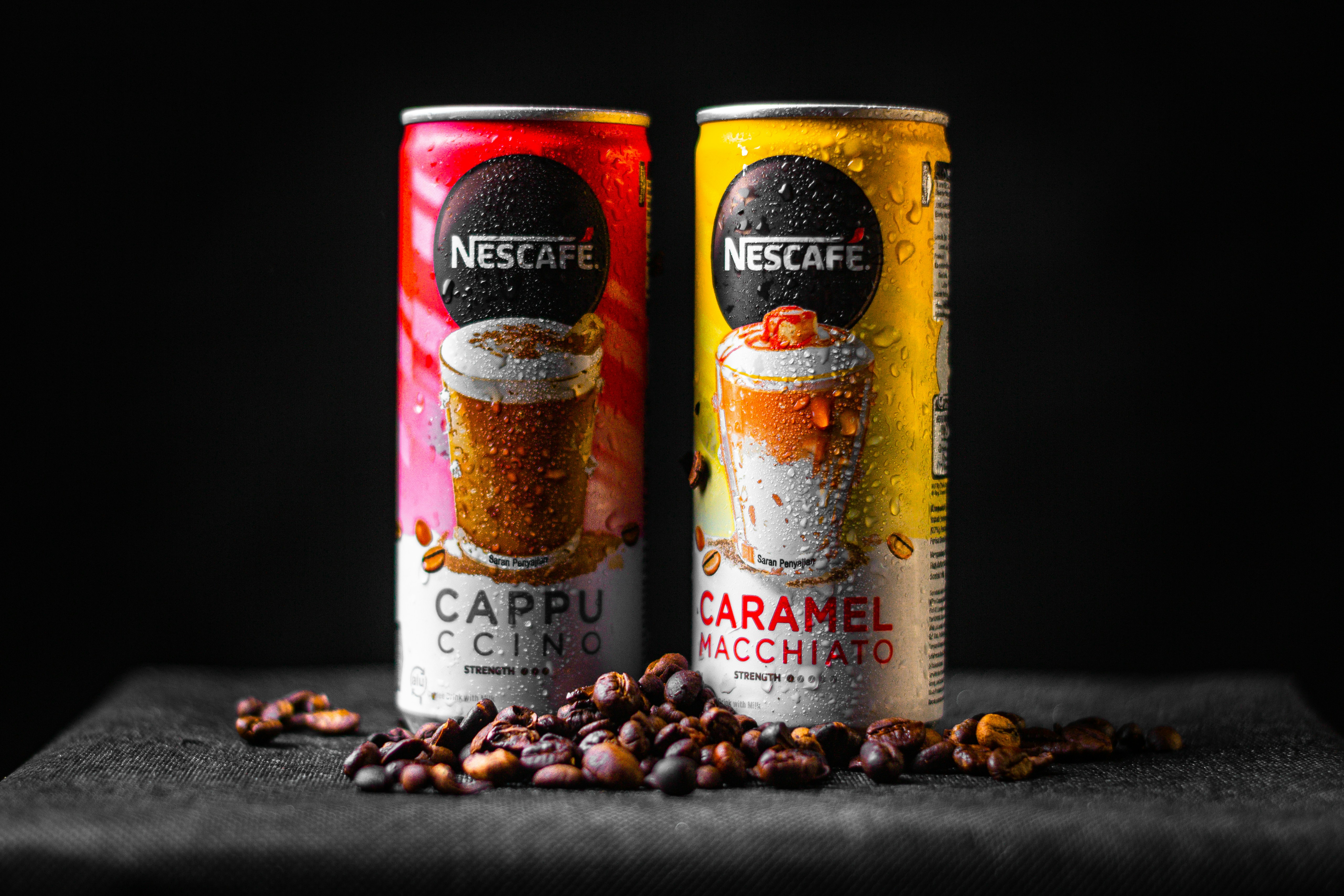 two cans of coffee sitting on top of a table