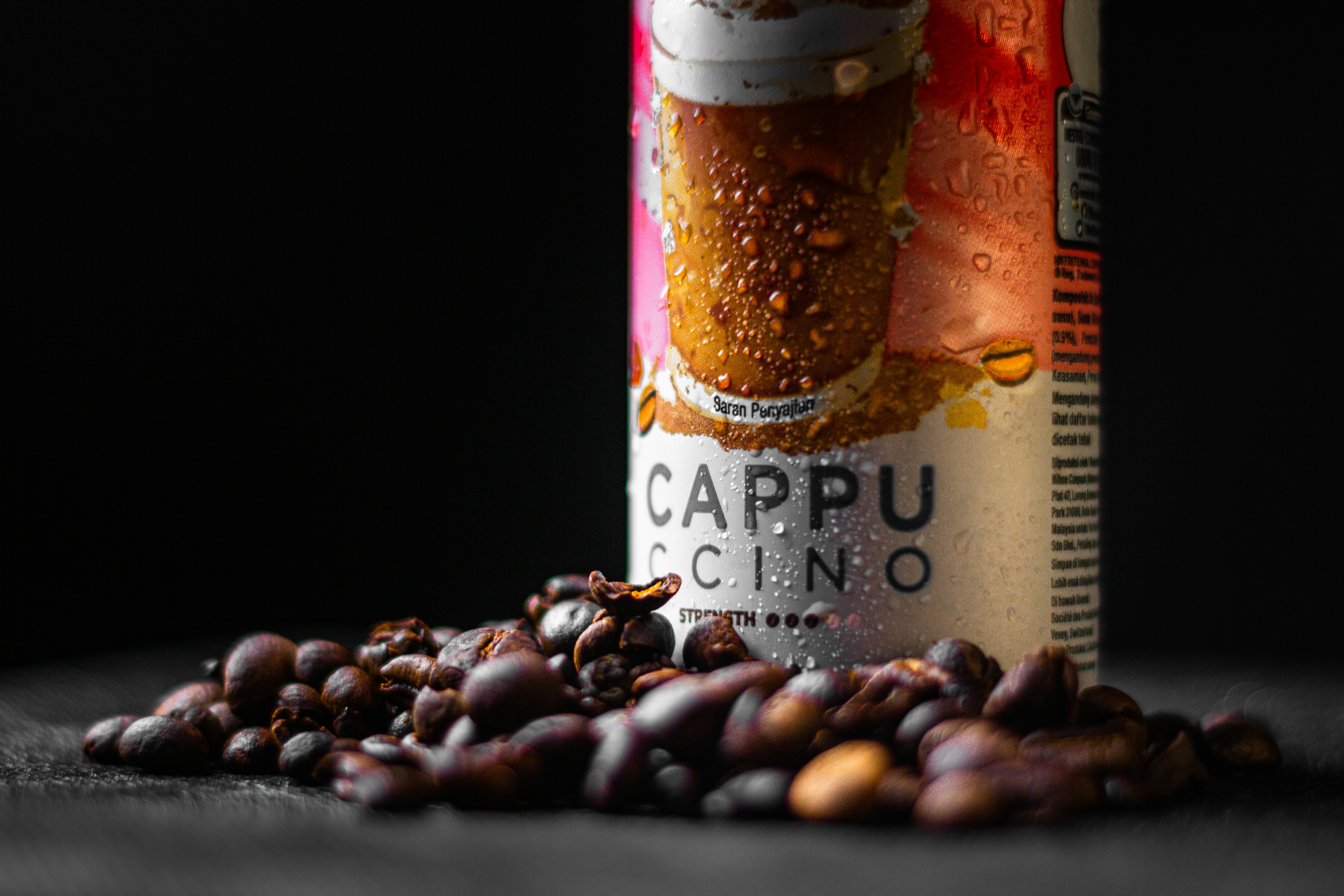 a can of cappuccino next to a pile of nuts