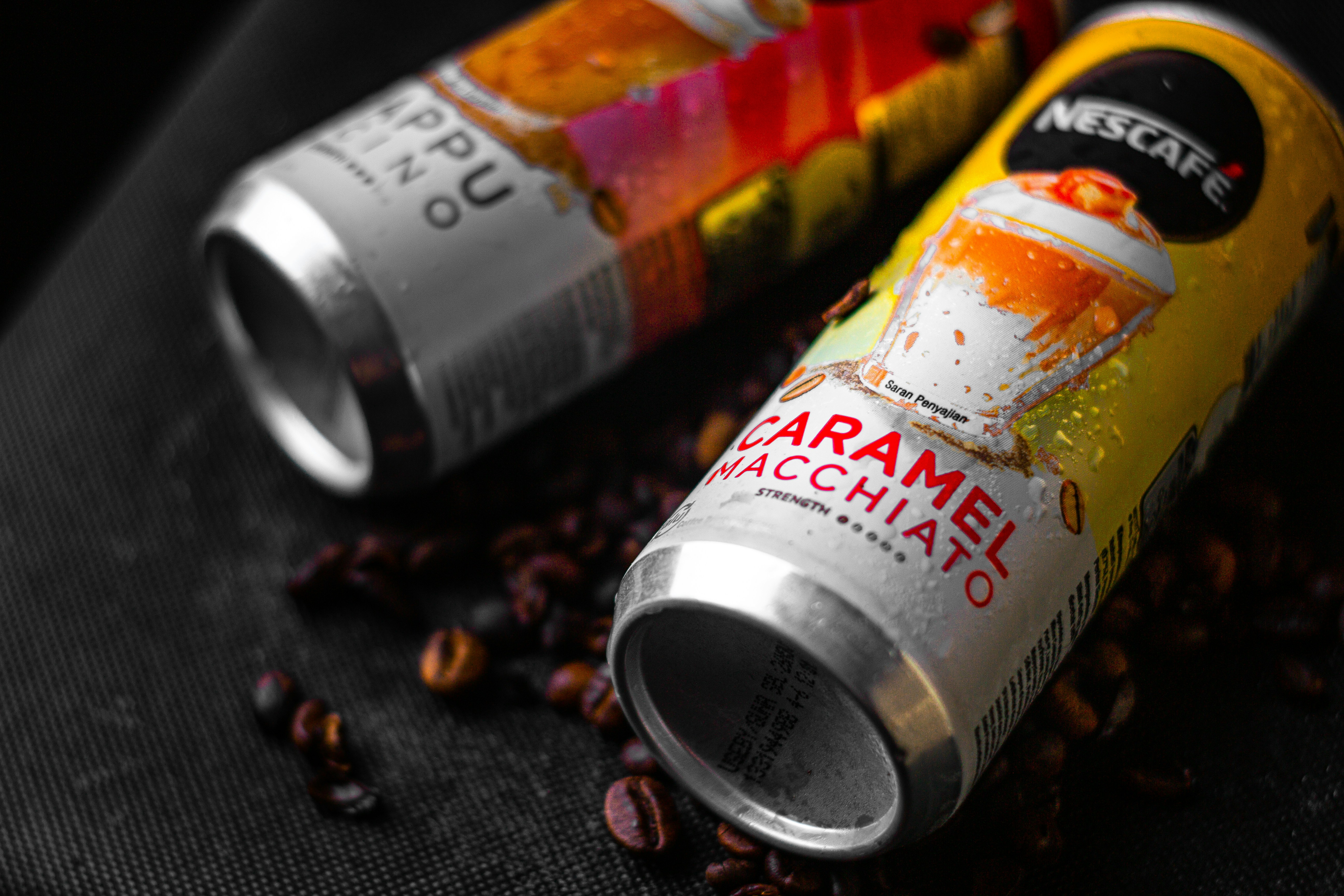 a couple of cans sitting on top of a pile of coffee beans