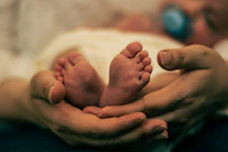 a close up of a person holding a baby