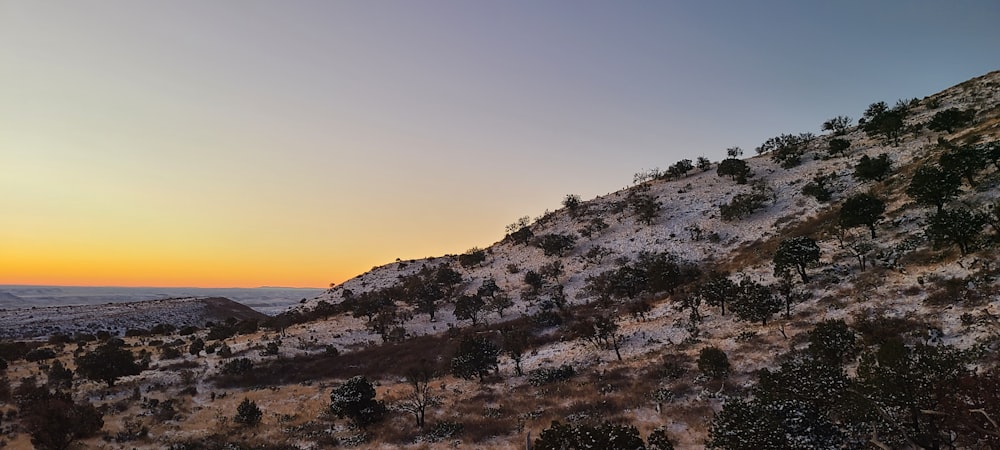 a snow covered mountain with a sunset in the background