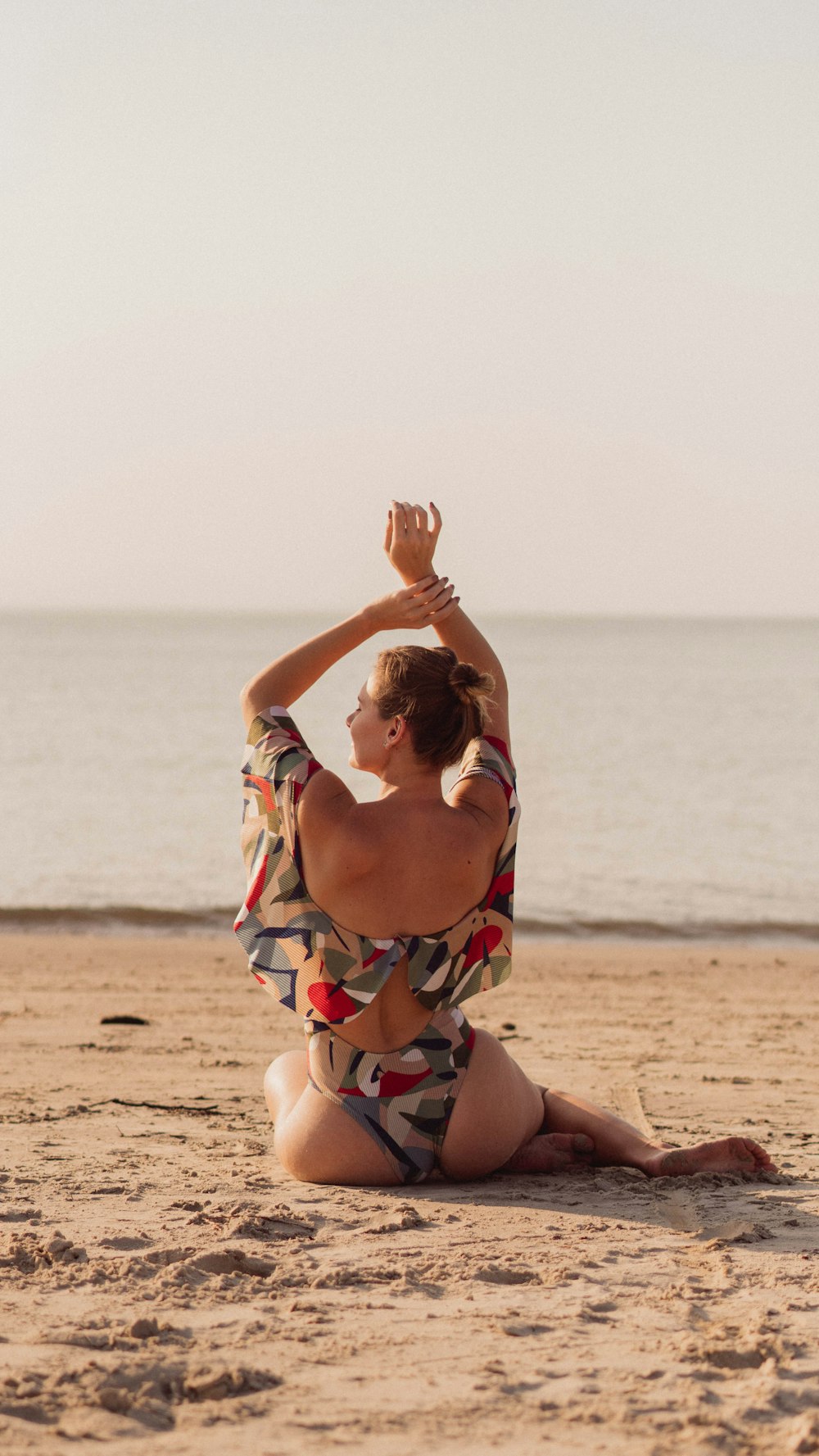 a woman in a bathing suit sitting on the beach