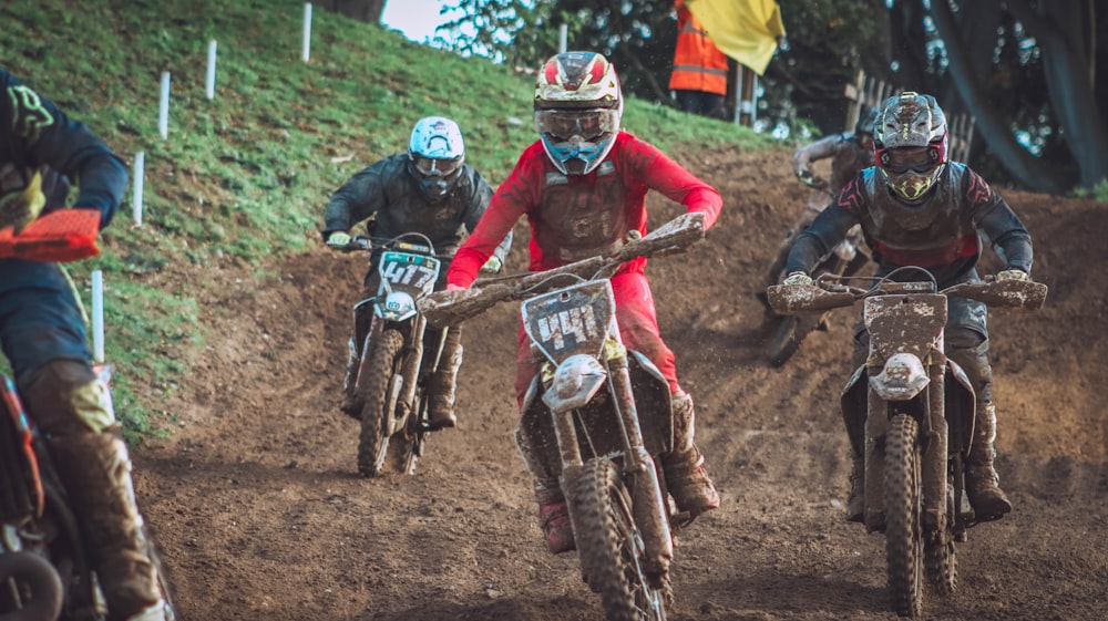 a group of people riding dirt bikes on a dirt track