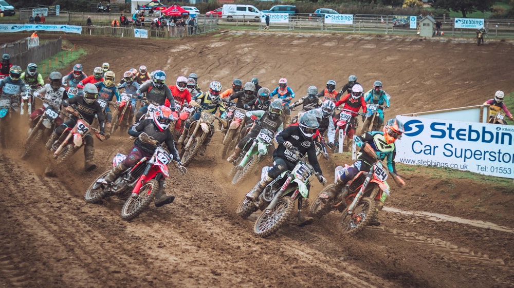 a group of people riding dirt bikes on a dirt track