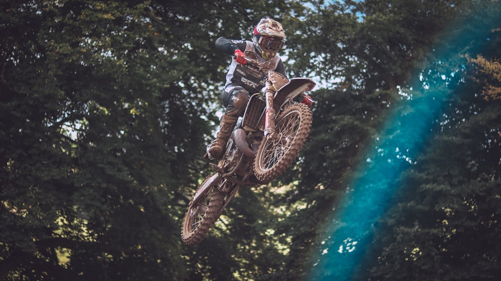 a man riding a dirt bike through the air