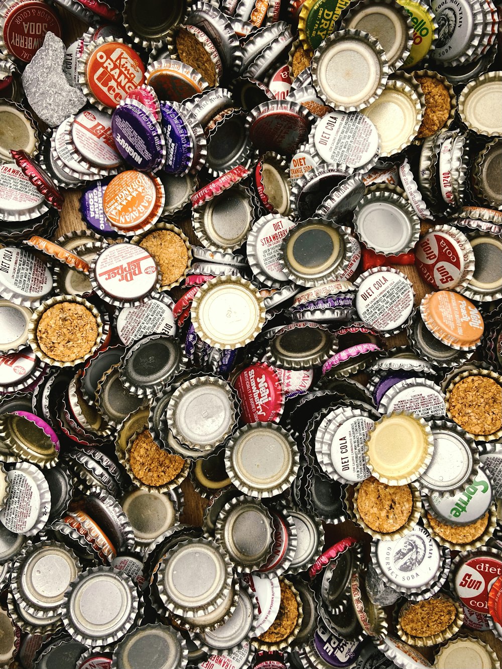a pile of beer bottle caps sitting on top of each other