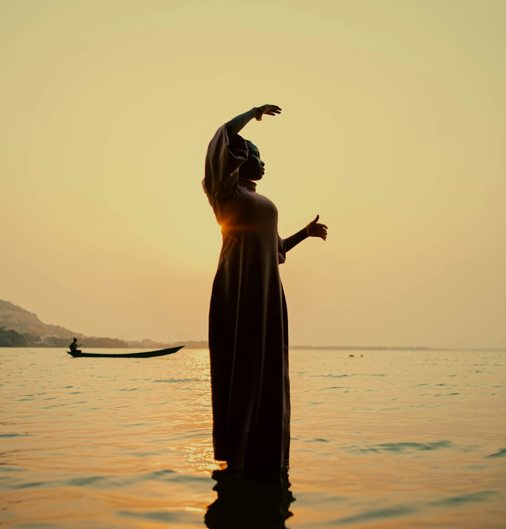 a woman in a long dress standing in the water