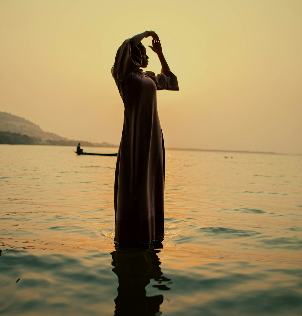 a man standing in the water with his hands on his head