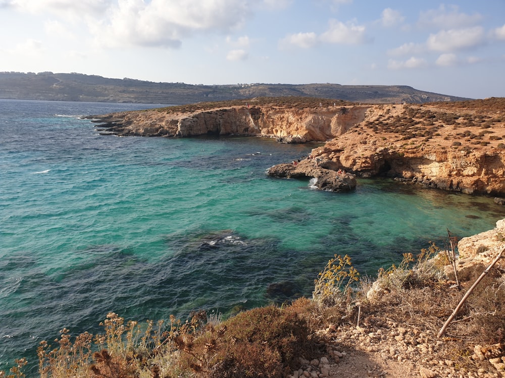 a body of water near a rocky shore