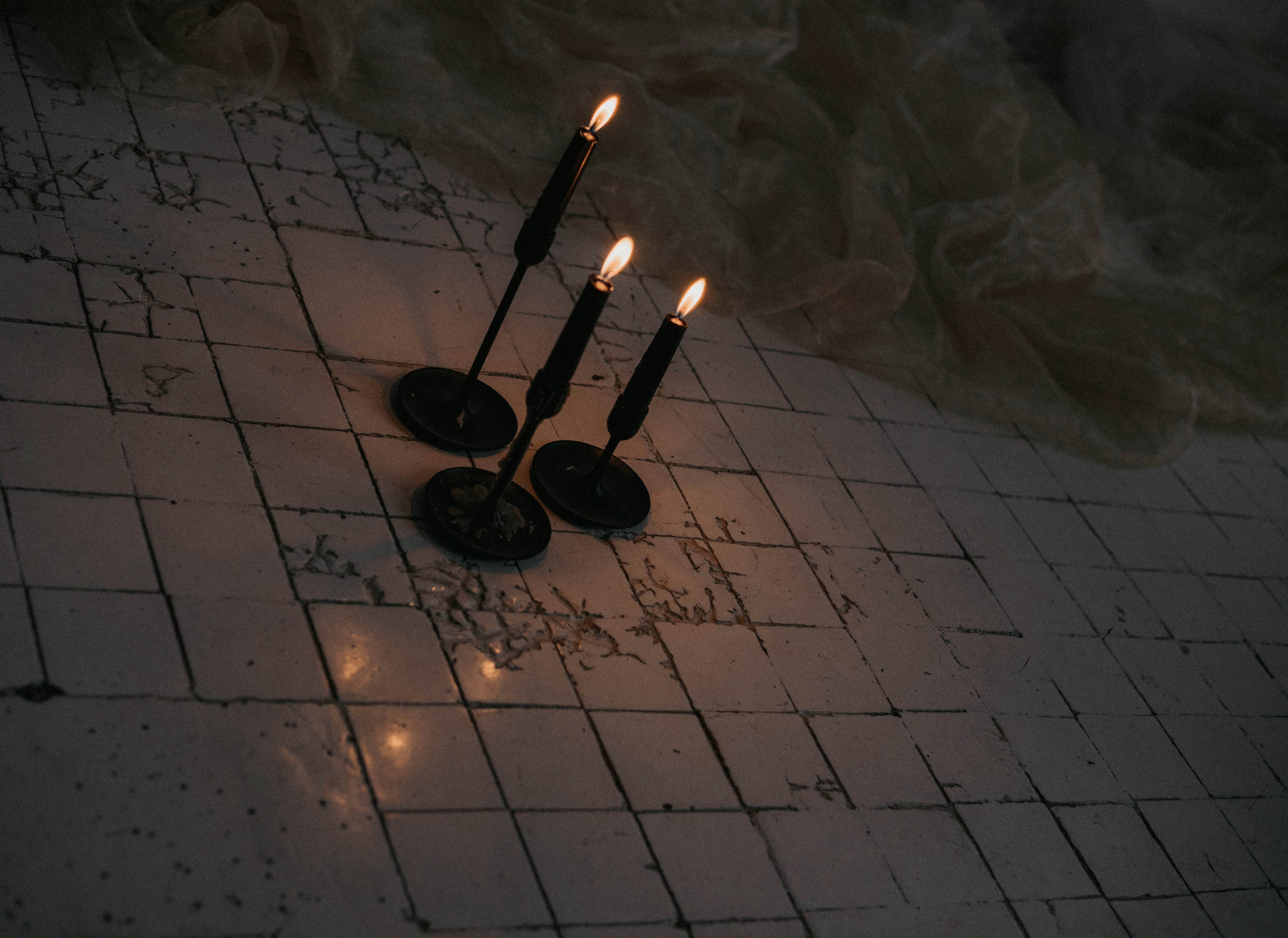 a couple of candles sitting on top of a white tiled floor