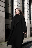 Model walking confidently down a city street wearing a sleek, modern trench coat.