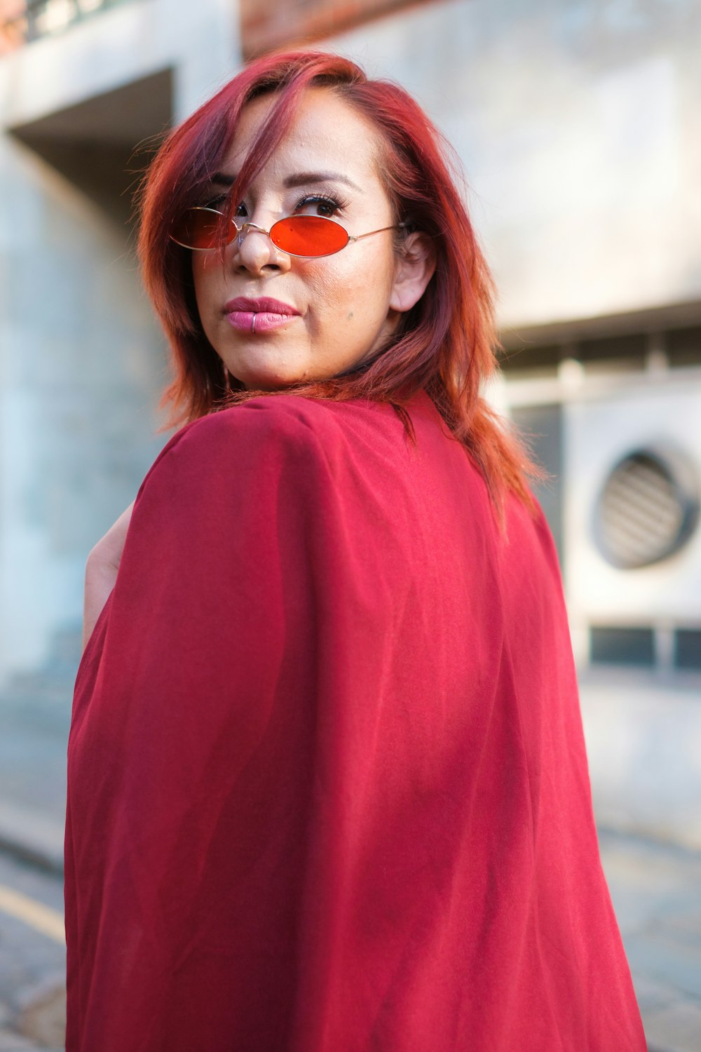 a woman in a red cape with a red eye patch