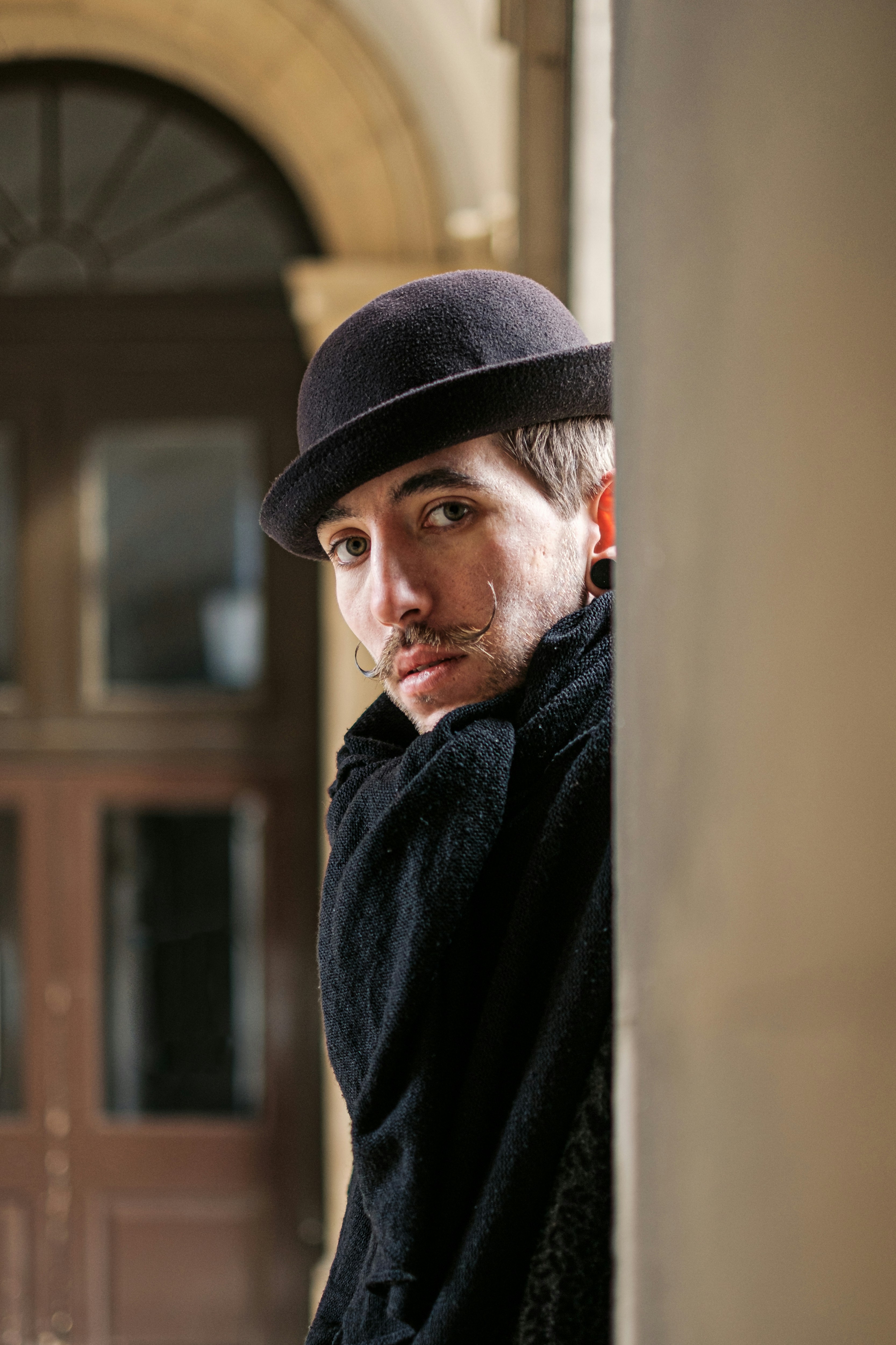 A man in a hat leaning against a wall photo – Free Uk Image on Unsplash
