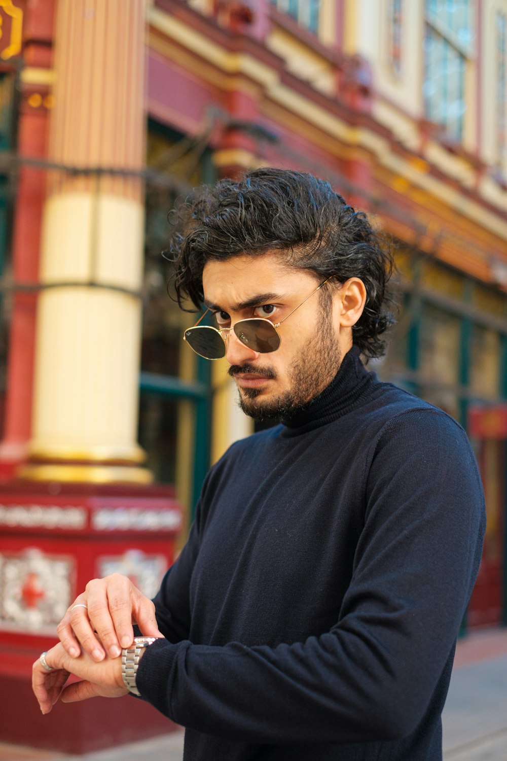 a man standing on a street corner looking at his cell phone