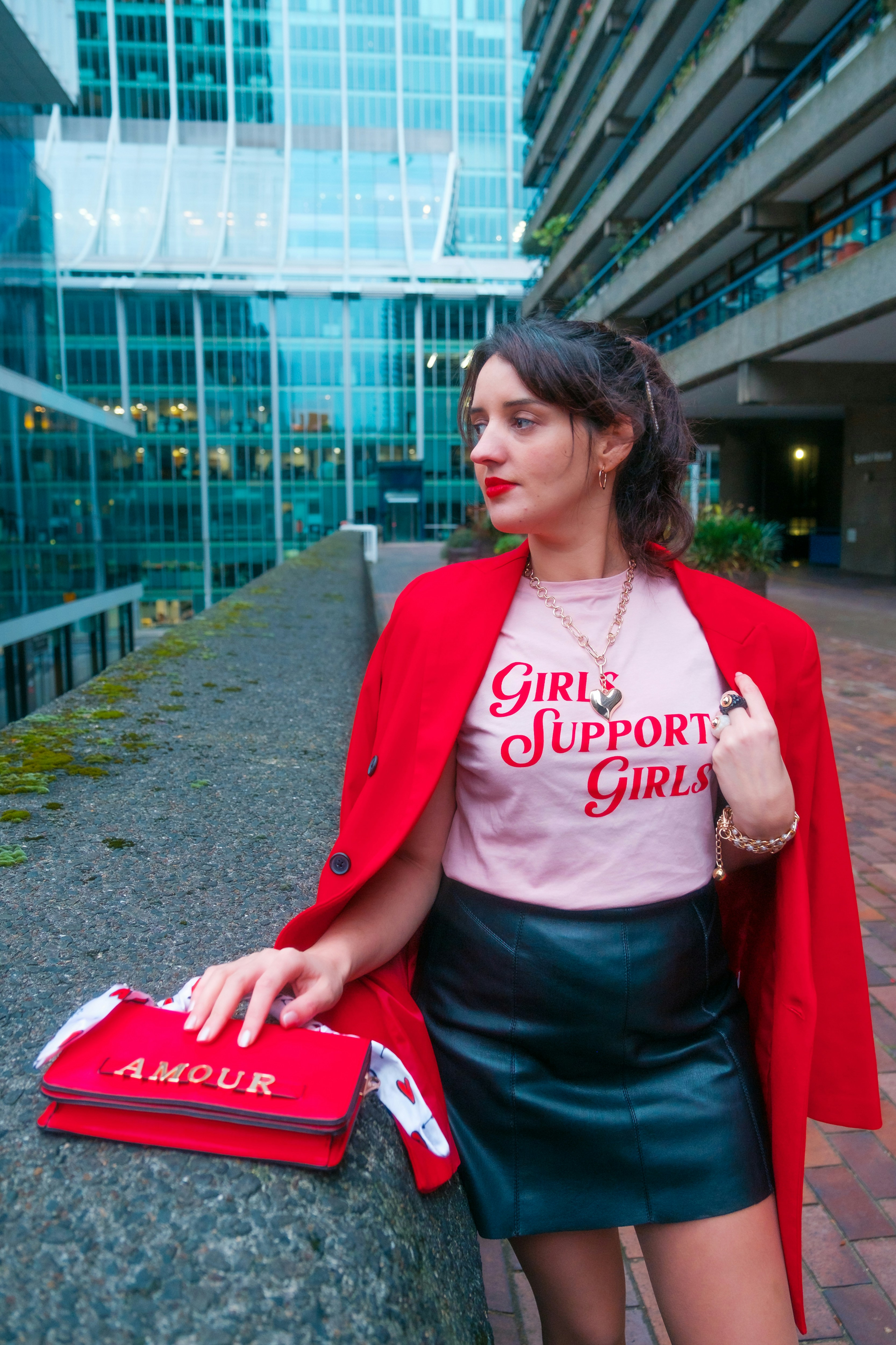 A woman in a red jacket leaning against a wall photo – Free London ...