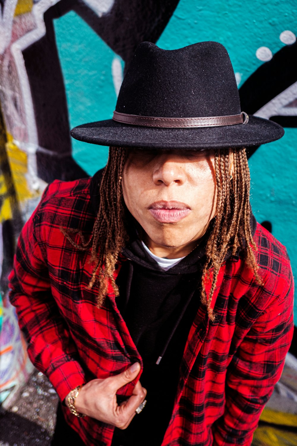 a man with dreadlocks wearing a black hat