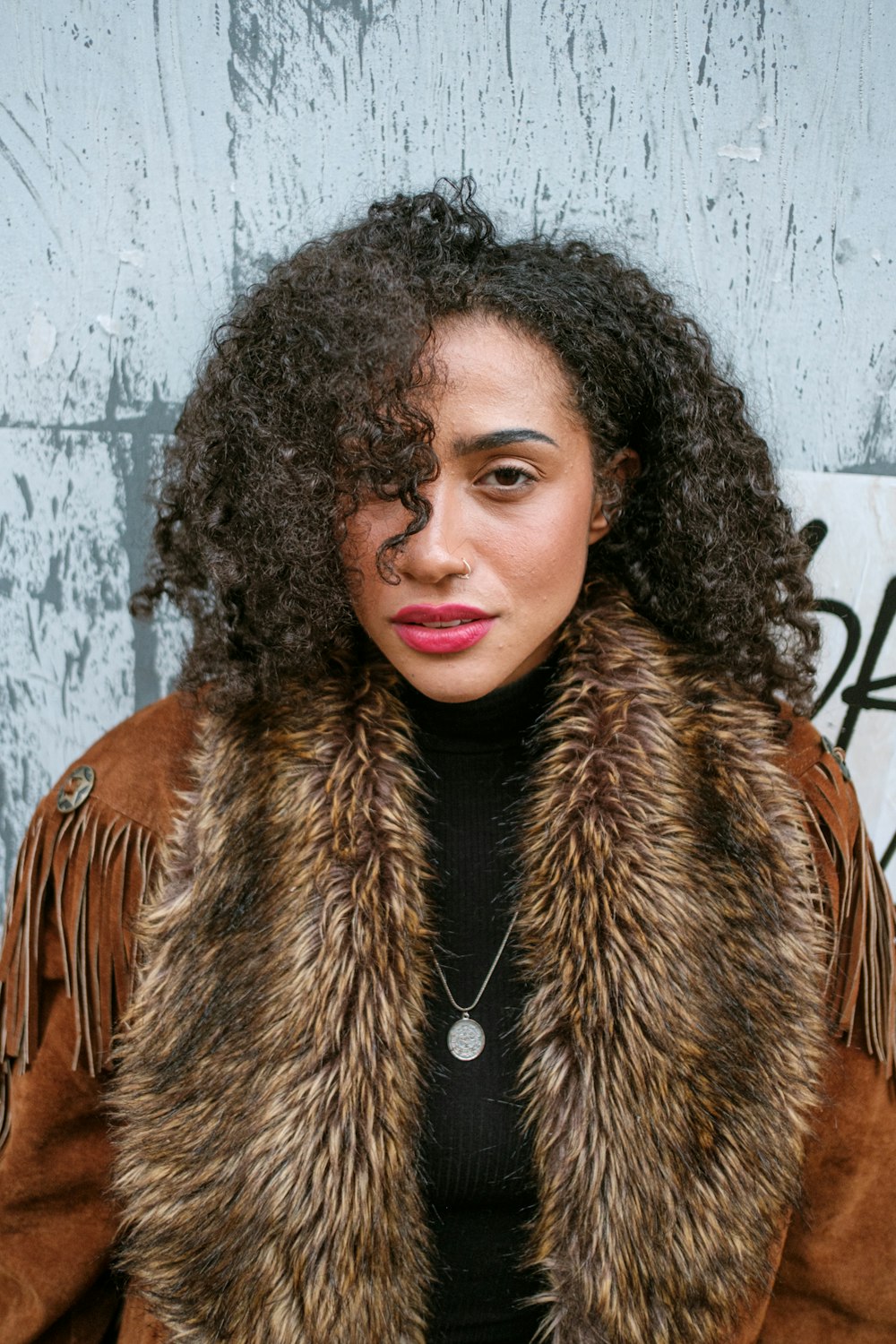 a woman wearing a fur coat and a necklace