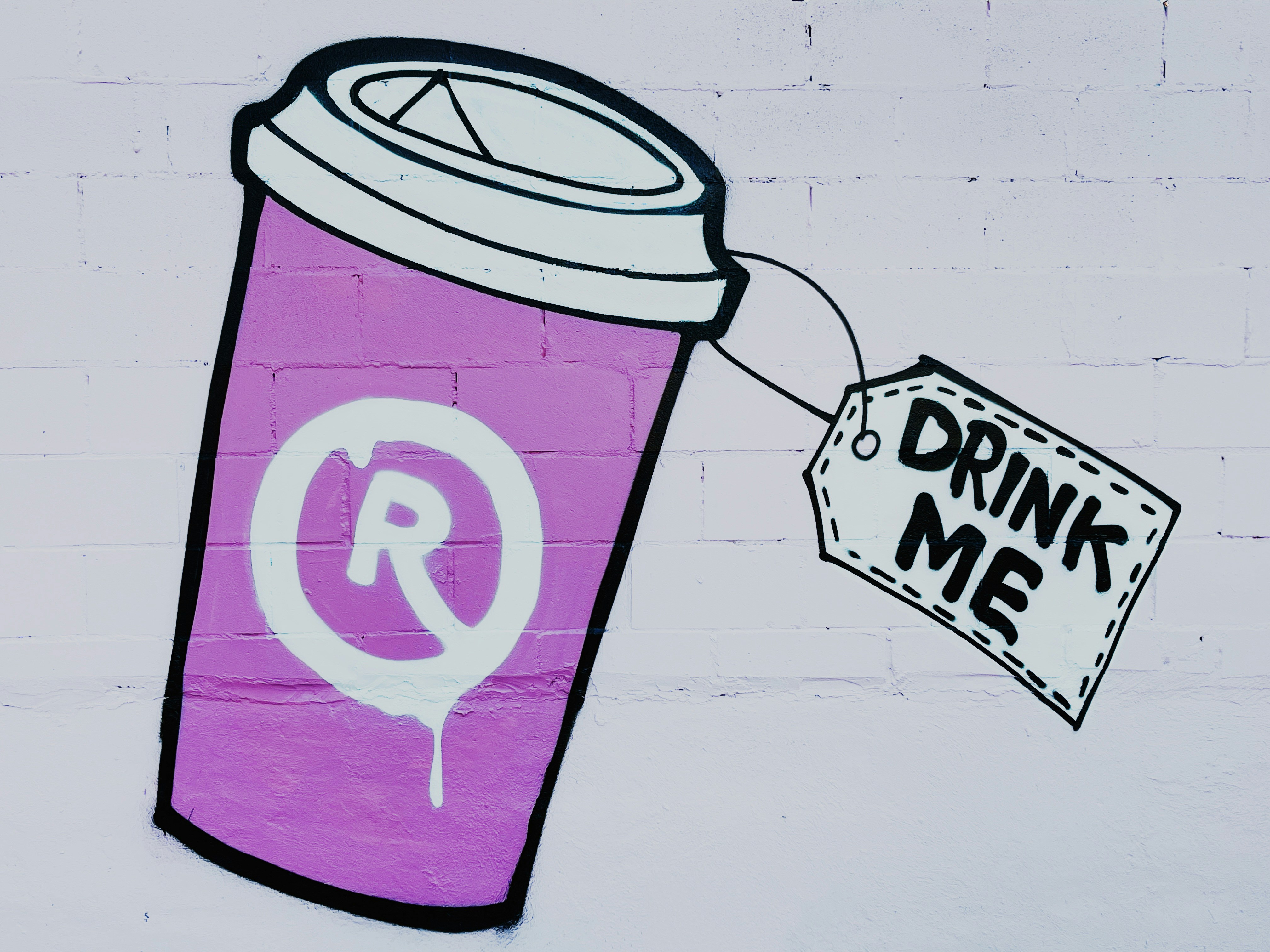 cangkir kopi ungu dengan tanda yang bertuliskan minum aku