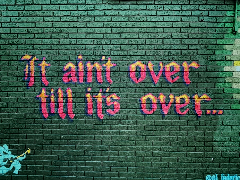 graffiti on a brick wall that says it's over till it's over