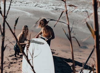 Close-up of hands repairing a surfboard using simple household tools outdoors