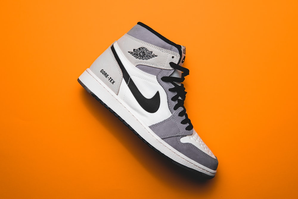 a pair of sneakers on an orange background